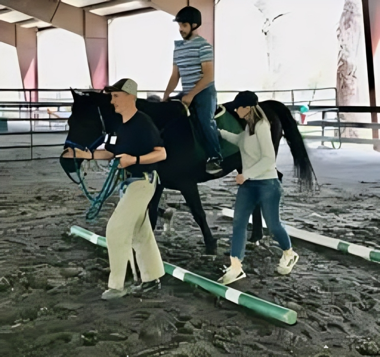 Indoor horse riding session with assistance