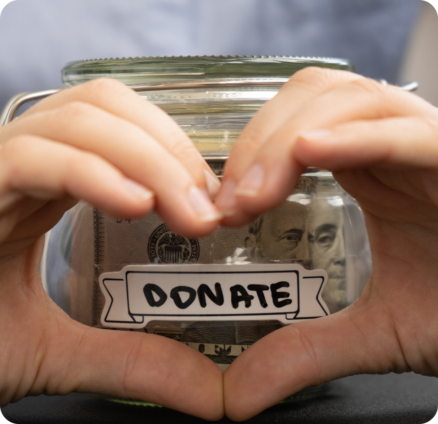 Hands forming heart around donation jar