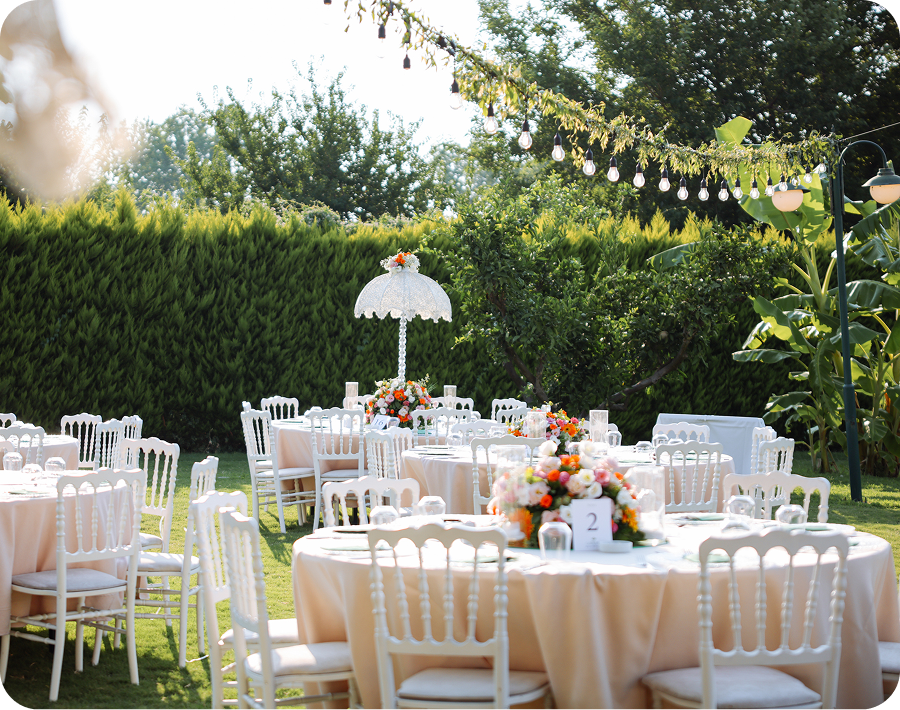 White chairs with floral centerpieces
