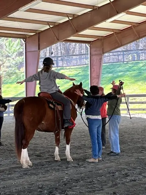 Horseback rider balancing with arms outstretched